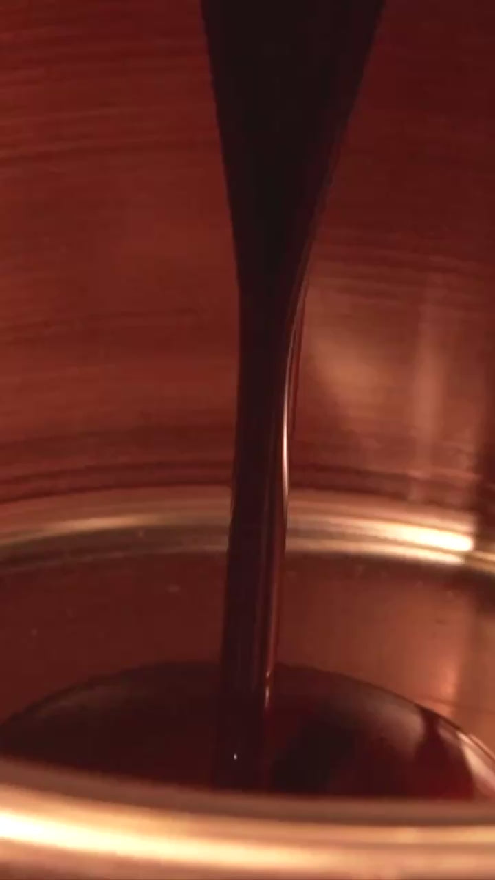 une cuve de cire lie de vin où est plongé un bouteille vide avec un bouchon en liege 